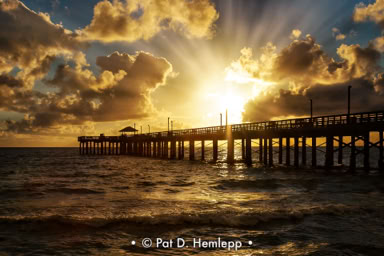 The sun rises behind Newport Fishing Pier in Sunny Isles Beach, Fla.
