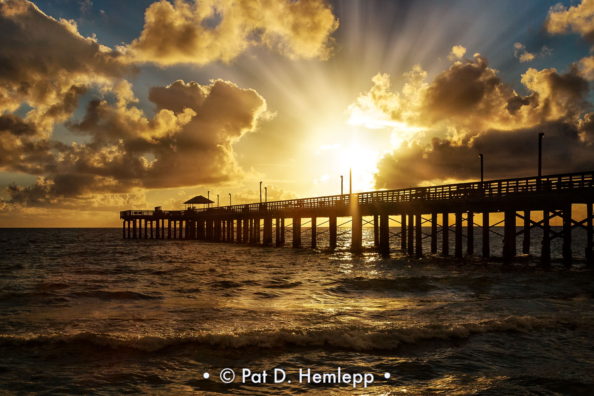 The sun rises behind Newport Fishing Pier in Sunny Isles Beach, Fla.
